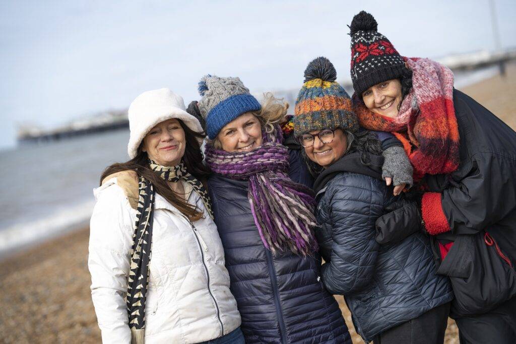 4 women in a group looking at camera. Surround yourself with supportive friends, family members, and fellow adventurers who share your passion for exploration