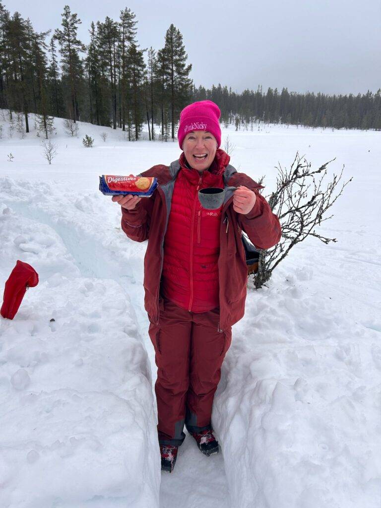 woman holding digestive biscuits on a frozen off-grid campsite