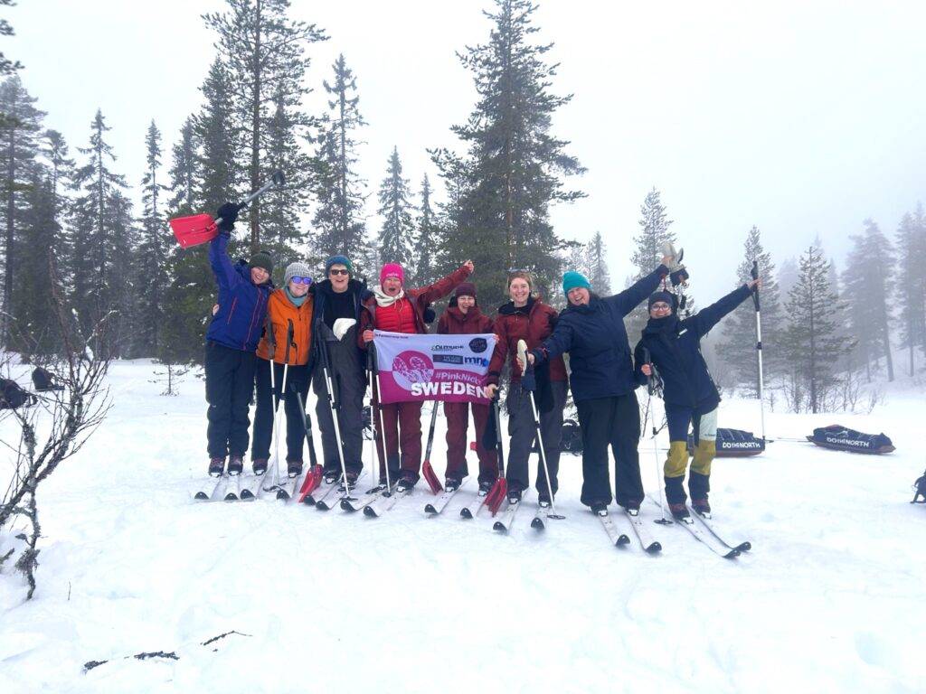 Team photo showing 8 women on skis in a forest in Sweden - celebrating off-piste-skiing