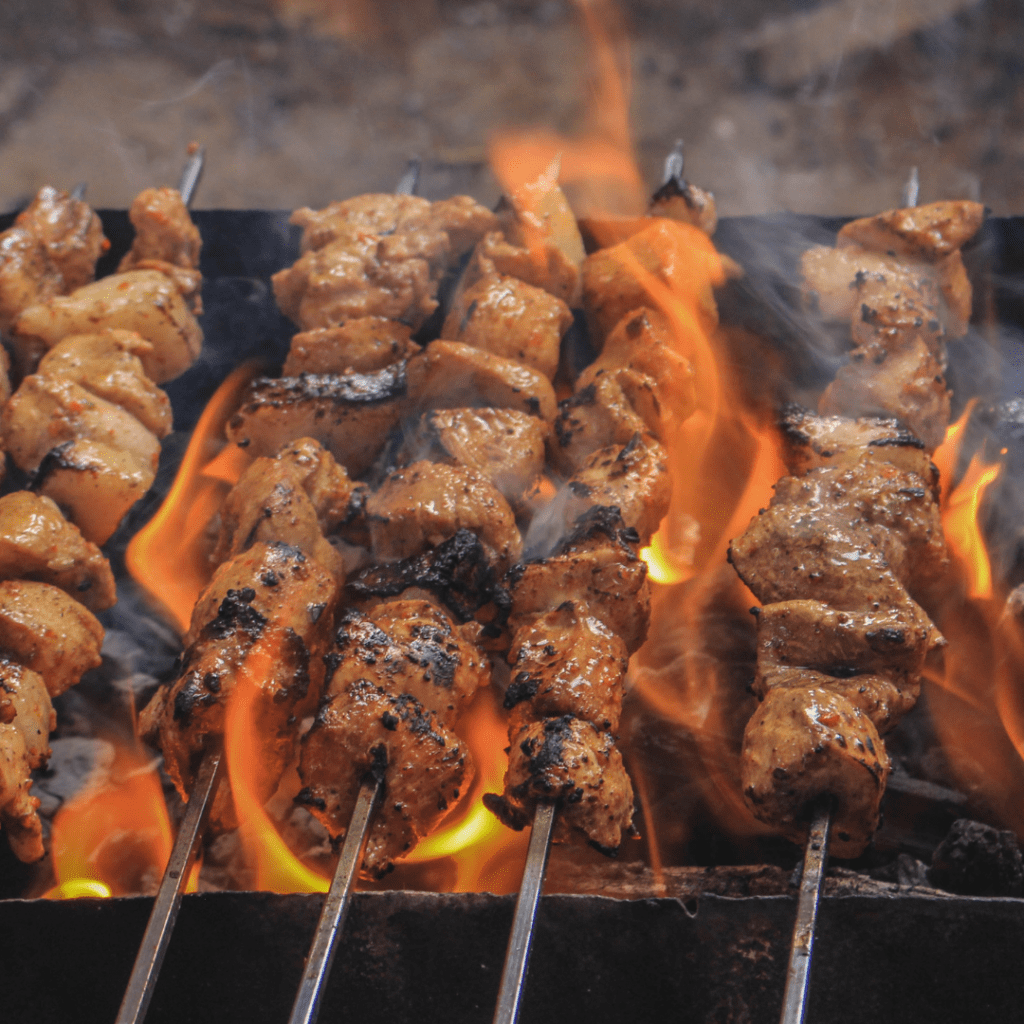 Outdoor fundraising event ideas: meat on bbq. shows kebabs ready to eat
