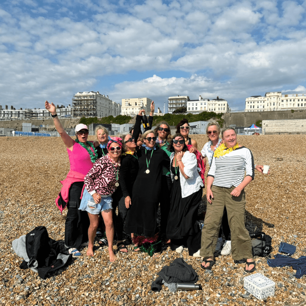 5km sea swim - group of women on the beach celebrating their successful swim